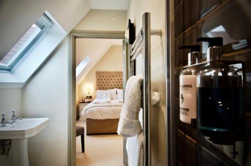 a bathroom with a sink and a bed and a mirror at Blacknest Golf and Country Club in Alton