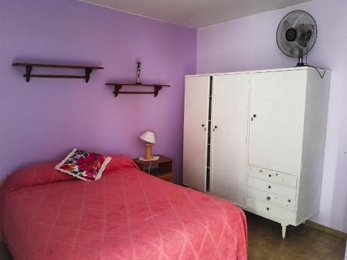 a bedroom with a bed and a white cabinet at Departamento amplio a metros del mar in Puerto Madryn