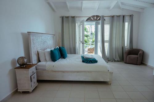 a bedroom with a large bed with blue pillows at El Mosquito Boutique Hotel Playa Bonita in Las Terrenas