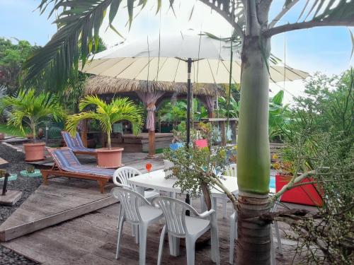 a patio with a table and chairs and an umbrella at Villa de 3 chambres avec piscine privee jardin clos et wifi a Sainte Anne a 6 km de la plage in Sainte-Anne
