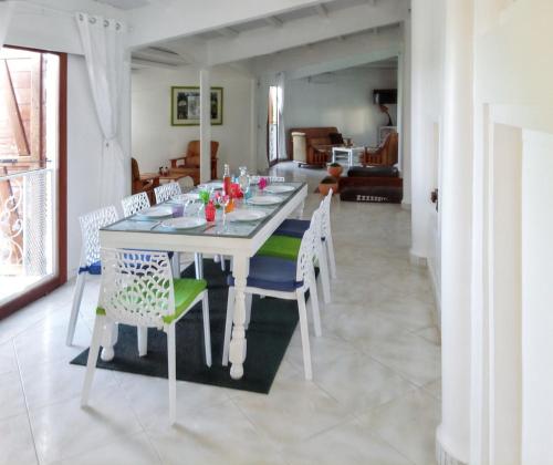a dining room with a white table and chairs at Villa de 3 chambres avec piscine privee jardin clos et wifi a Sainte Anne a 6 km de la plage in Sainte-Anne