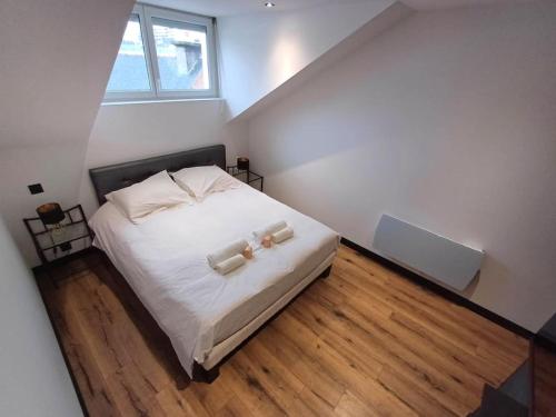 une chambre avec un lit avec deux oreillers blancs dans l'établissement Le Hermès, à Lorient