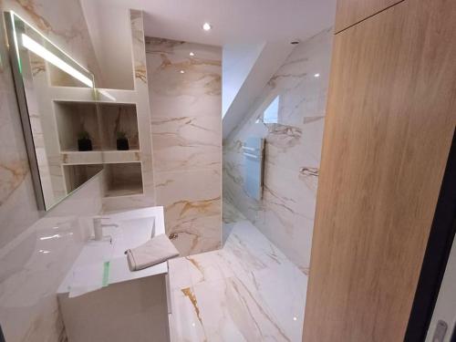 une salle de bain blanche avec un lavabo et un miroir dans l'établissement Le Hermès, à Lorient