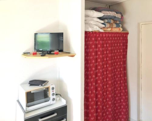 Cette chambre dispose d'un four micro-ondes et d'un rideau rouge. dans l'établissement Studio avec wifi a Le Devoluy, à Saint-Étienne-en-Dévoluy