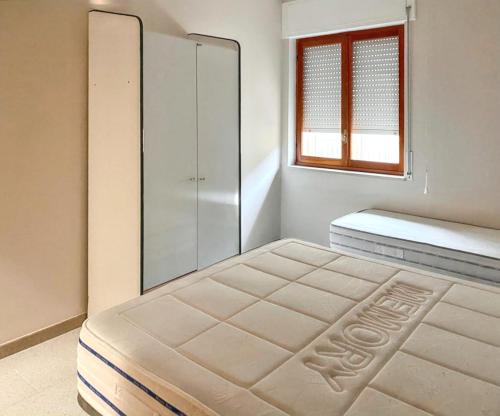 ein weißes Schlafzimmer mit einem Bett und einem Fenster in der Unterkunft 2 bedrooms apartement with city view and terrace at Torre Melissa in Torre Melissa
