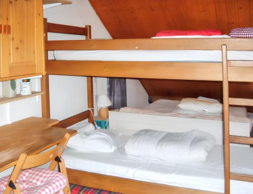 a room with three bunk beds and a table at Studio a Aiguilles a 5 km des pistes in Aiguilles