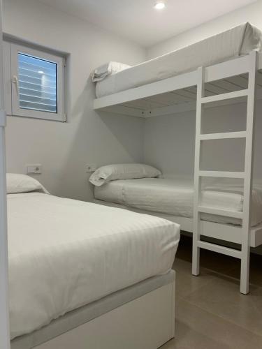 a bedroom with two bunk beds and a window at Apartamento Almadraba in Roses