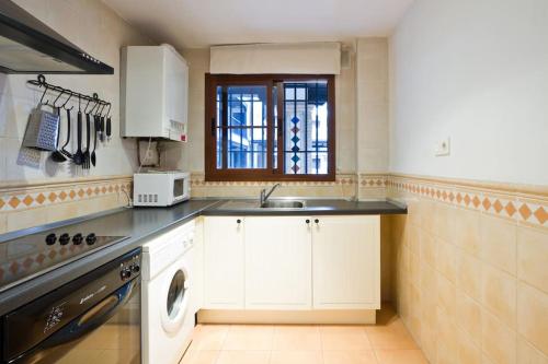 a kitchen with white cabinets and a sink at Entre la Alhambra y Sierra Nevada in Monachil