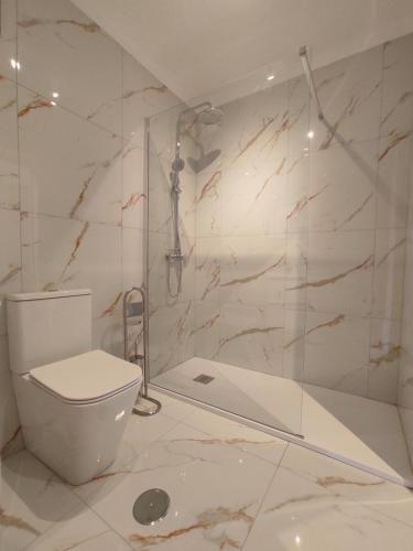 a white bathroom with a toilet and a shower at Maria Luxury Apartament Golf del Sur Tenerife in San Miguel de Abona