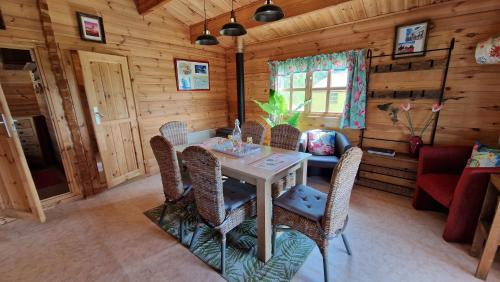 een eetkamer met een tafel en stoelen in een hut bij CAMPING LA PERLE in La Rochette