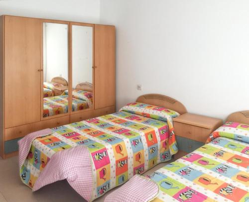- une chambre avec 2 lits et un miroir dans l'établissement 3 bedrooms apartement at Laxe 80 m away from the beach with balcony, à Laxe