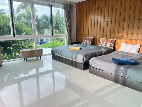 une chambre avec deux lits et une grande fenêtre dans l'établissement Cloud villa, à Pattaya (sud)