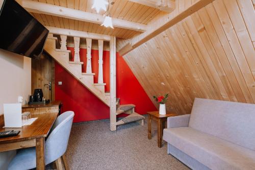 a living room with a couch and a staircase at Góralski Gościniec & SPA in Poronin