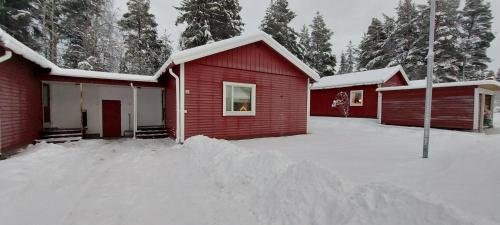 una pila de nieve frente a una casa roja en Vindelälv Stuga in Blattnicksele, en Blattniksele