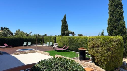 a backyard with a garden with chairs and a table at Eco Natura Falcoeira - Praia da Luz in Montinhos da Luz