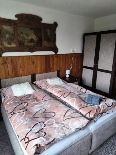 a bedroom with a large bed with a blanket at Chata Rybná 18 in Pernink