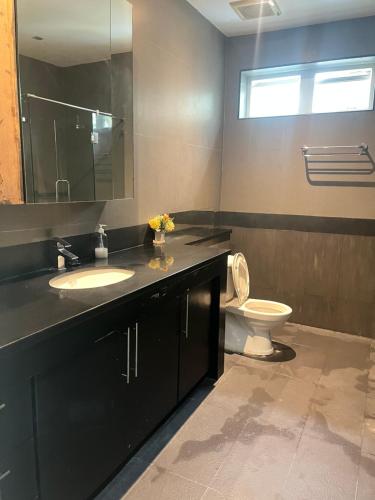 une salle de bain avec toilettes, lavabo et miroir dans l'établissement Cloud villa, à Pattaya (sud)