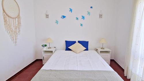 a bedroom with a bed with blue birds on the wall at Casa Vista Mar in Luz