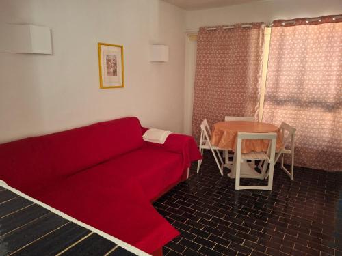 a living room with a red couch and a table at Balaia Gardens, jardins da Balaia in Albufeira