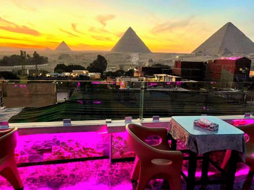 a restaurant with a table and a view of the pyramids at MagiC Pyramids INN in Cairo