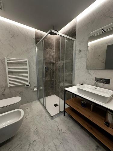 a bathroom with a shower and a sink and a toilet at GRANDI 32 Boutique Residence in Segrate