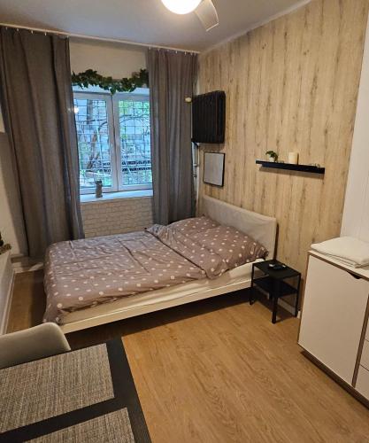 Schlafzimmer mit einem Bett und einem Fenster in der Unterkunft Smulik Flat 21 in Warschau