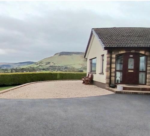 a house with a bench in front of it at Cullentra House in Cushendall