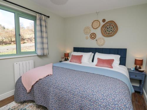 a bedroom with a large bed with two pink pillows at Dol Blodau in Llandrindod Wells