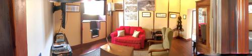 een woonkamer met een rode stoel in een kamer bij One bedroom house at Garachico 600 m away from the beach with city view furnished terrace and wifi in Garachico