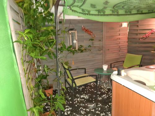 a room with a table and chairs and plants at Appartement d'une chambre avec piscine partagee jacuzzi et jardin clos a Sainte Rose a 3 km de la plage in Sainte-Rose