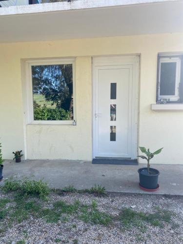 Beaupontにあるappartementの白い扉と鉢植えの家