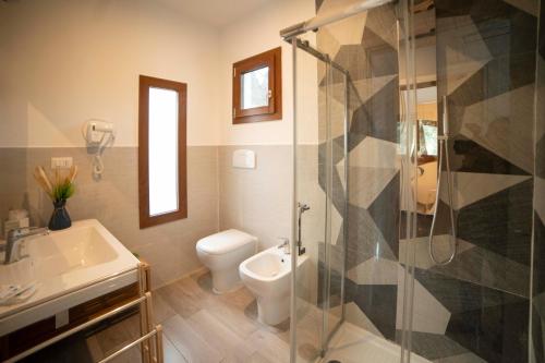 ein Bad mit einer Dusche, einem WC und einem Waschbecken in der Unterkunft saracena Holiday Home with Private Beach and Swimming Pool in Mattinata