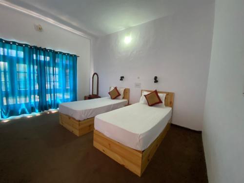 um quarto com 2 camas e uma janela em Hotel Skittsal Leh em Leh