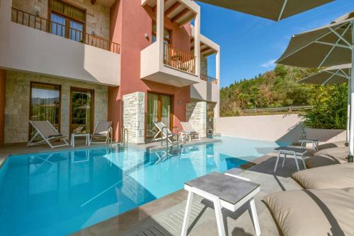 a villa with a swimming pool and a house at Aria Luxury Residence in Syvota