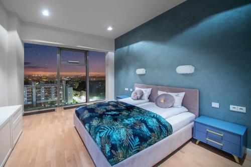 Apartamenty w Sky Tower في فروتسواف: غرفة نوم بسرير كبير بجدار ازرق