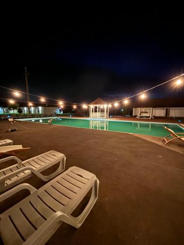 a tennis court at night with white lounges on the court at Complex Daniel's in Orăştie