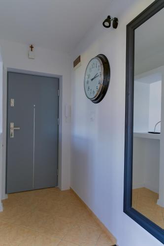 a clock on a wall next to a door at Mieszkanie do wynajęcia Kraśnik in Kraśnik