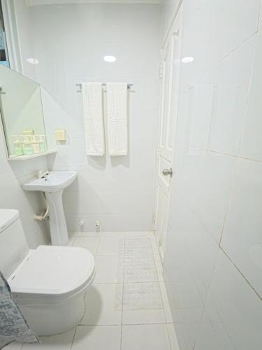 a white bathroom with a toilet and a sink at Urban Stays by Empress in Hulhumale