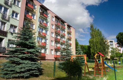 a playground in front of a building with a christmas tree at Mieszkanie do wynajęcia Kraśnik in Kraśnik