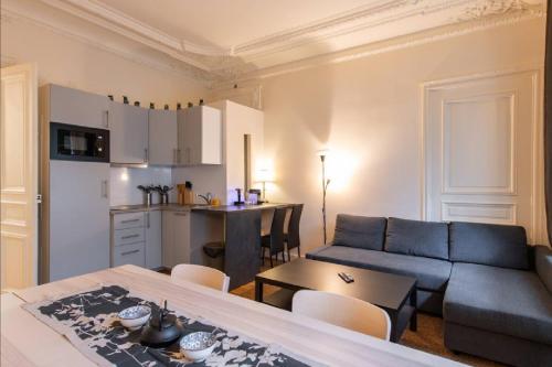 un salon avec un canapé et une table dans l'établissement Geranimus Morland : Hearth of Paris, à Paris
