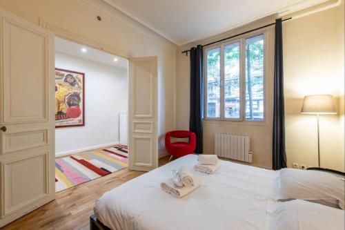 une chambre avec un lit blanc et une chaise rouge dans l'établissement Geranimus Morland : Hearth of Paris, à Paris