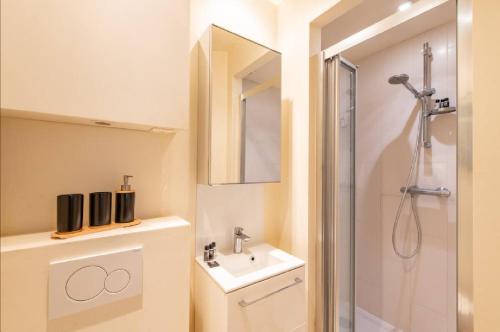 une salle de bain avec douche et lavabo dans l'établissement Geranimus Morland : Hearth of Paris, à Paris