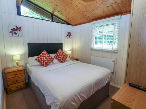 sypialnia z dużym białym łóżkiem z czerwonymi poduszkami w obiekcie Ash Lodge w mieście Ripon