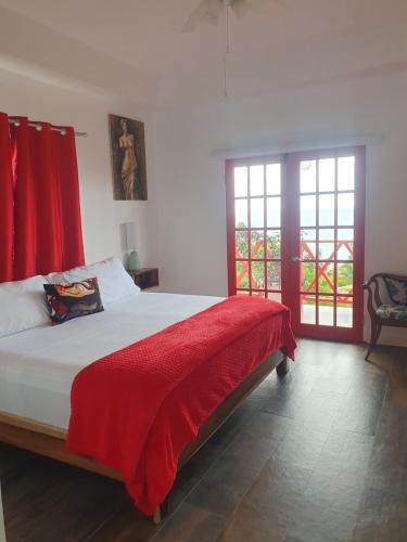 Kai's Place at Tim Pappies 3rd Floor luxury villa في بورت أنطونيو: غرفة نوم بسرير وبطانية حمراء
