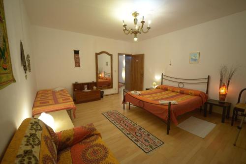sypialnia z 2 łóżkami, kanapą i lustrem w obiekcie B&B Arabesque w Wenecji