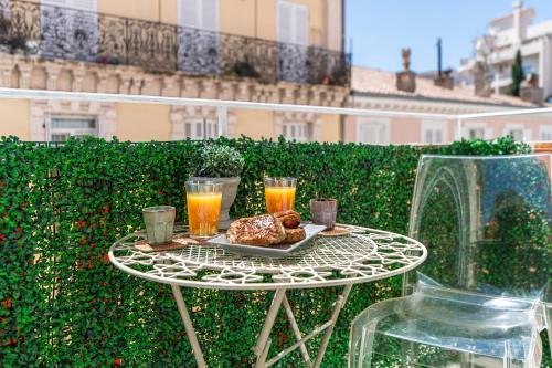 - une table avec un plateau de nourriture et 2 verres de jus d'orange dans l'établissement Magnifique studio centre Cannes Vieux port-Croisette-Plages, à Cannes