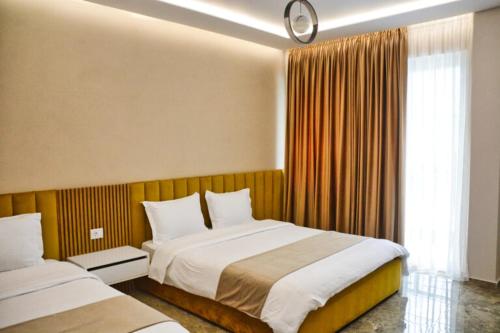 a hotel room with two beds and a window at Bujtina Oxhaku in Peshkopi