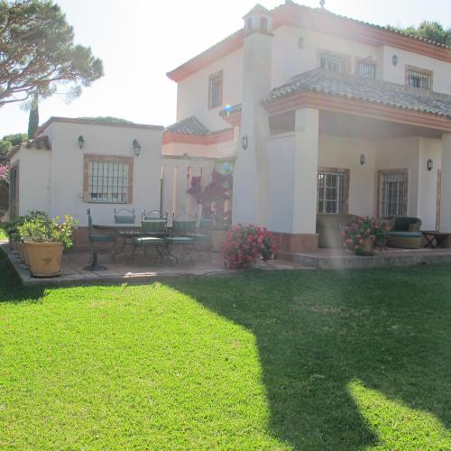 a large white house with a patio and a yard at Villa Alegría in Roche