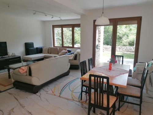 ein Wohnzimmer mit einem Sofa, einem Tisch und Stühlen in der Unterkunft Pelister Riverside Villa in Bitola