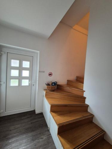a staircase in a house with wooden floors and a door at Oddih v mirnem in zelenem okolju in Škofljica